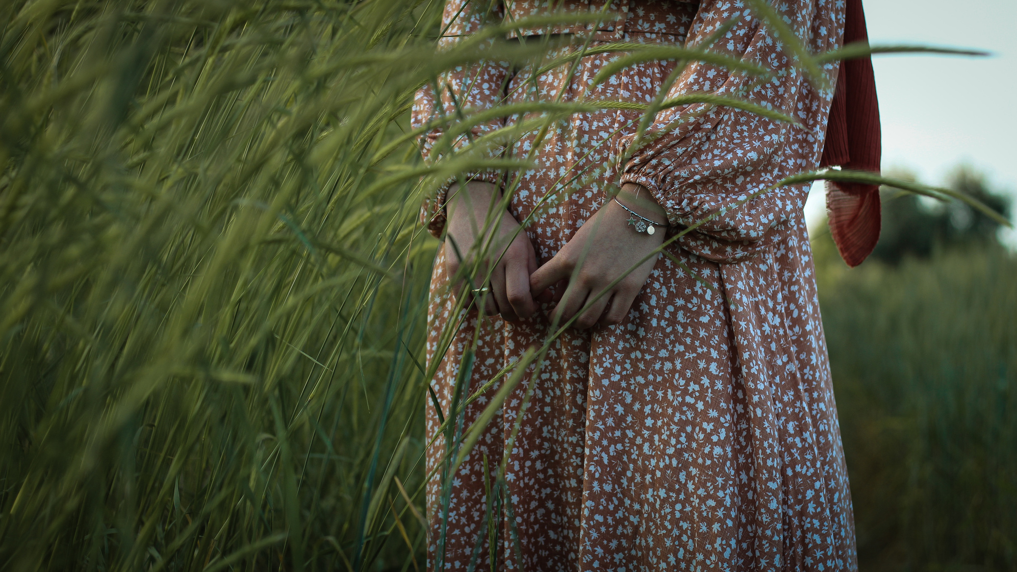 Crop woman in boho dress standing in field